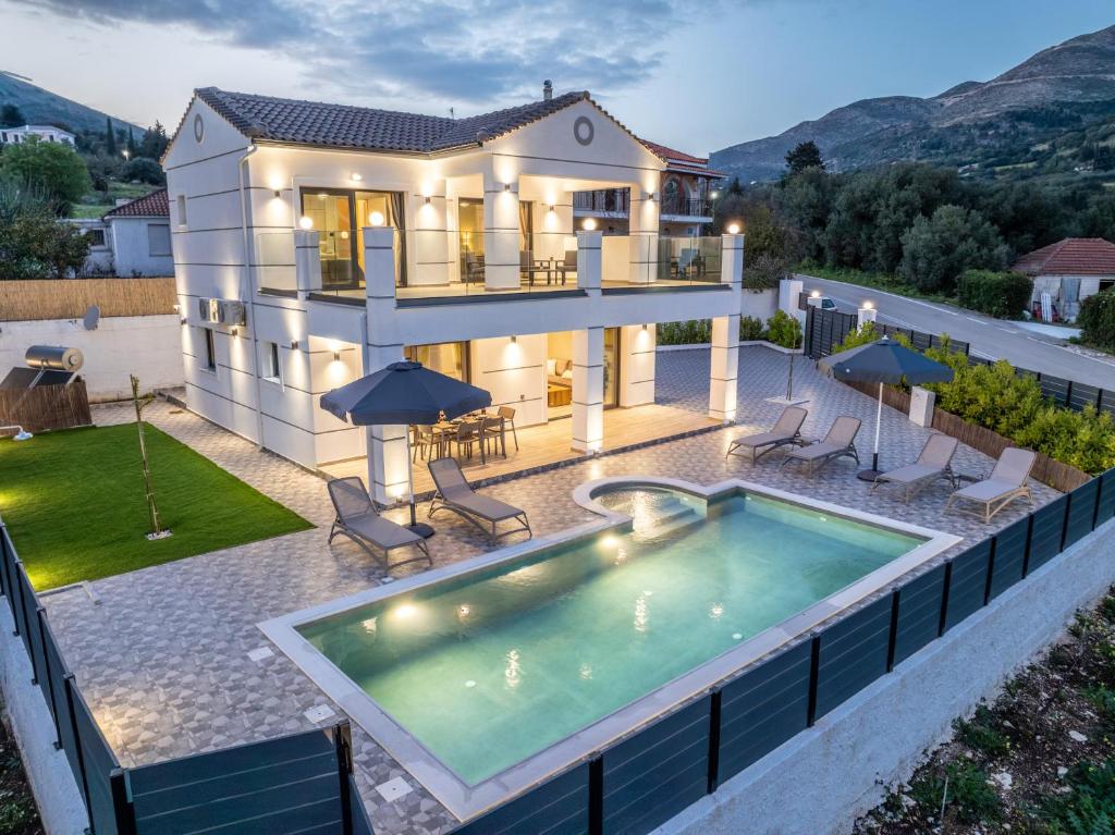 a villa with a swimming pool and a house at Villa La Bianca in Marketáta