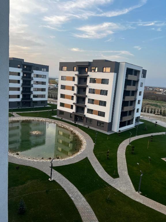 two large buildings with a pond in a park at Focsani Studio Residence 3 in Focşani