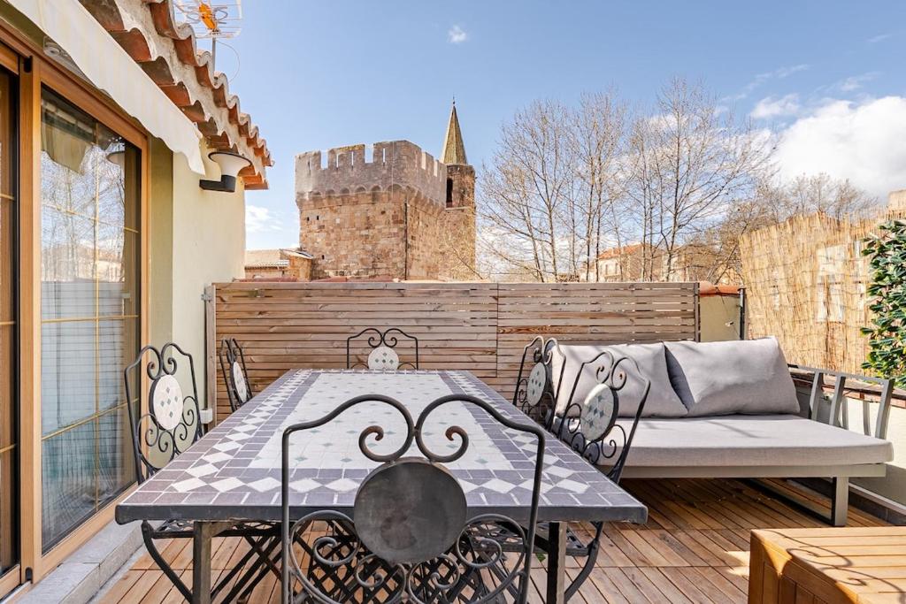 a table and chairs on a balcony with a castle in the background at Duplex 2chambres avec Terrasse Centre Historique in Fréjus