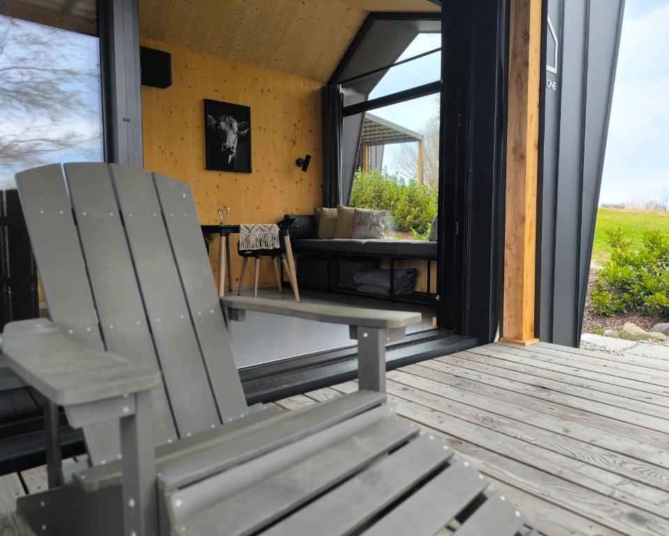 a wooden porch with a bench and a table at Tiny House 1 im schönen Allgäu mit großem Garten, Naturnah in Bad Wurzach