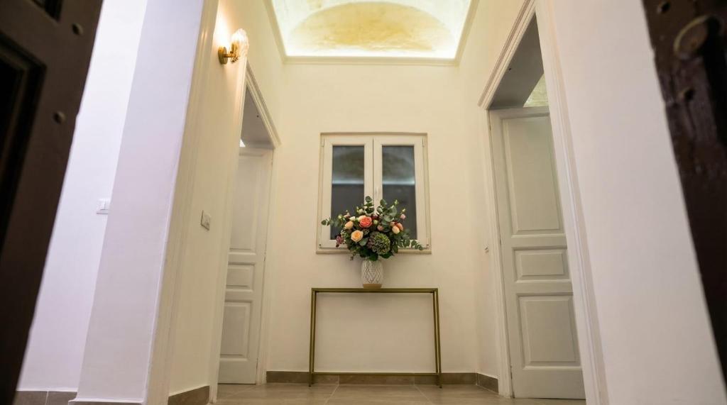 a hallway with a door and a vase of flowers at La Casa del Faro in Taranto