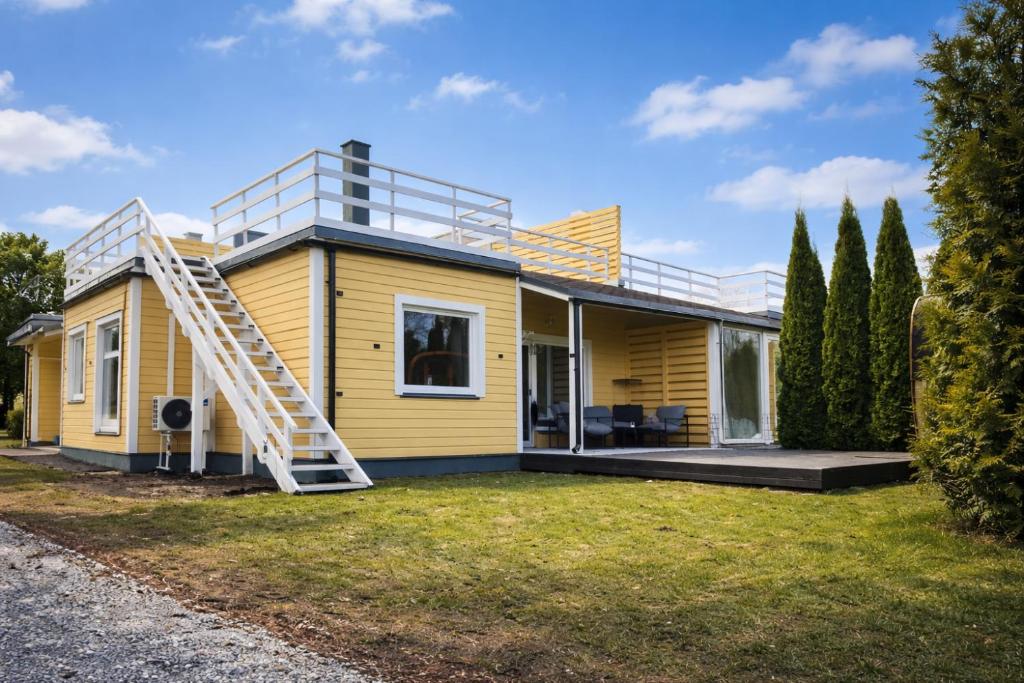 a yellow house with a ladder on top of it at Kusagil Nature & Sauna near Pärnu in Tahkuranna