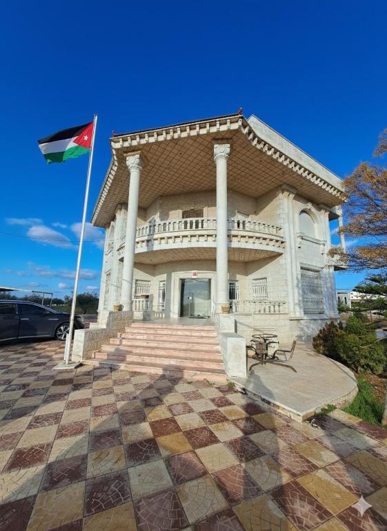 a building with a flag in front of it at فيلا الاحلام السعيدة in Ar Ramthā