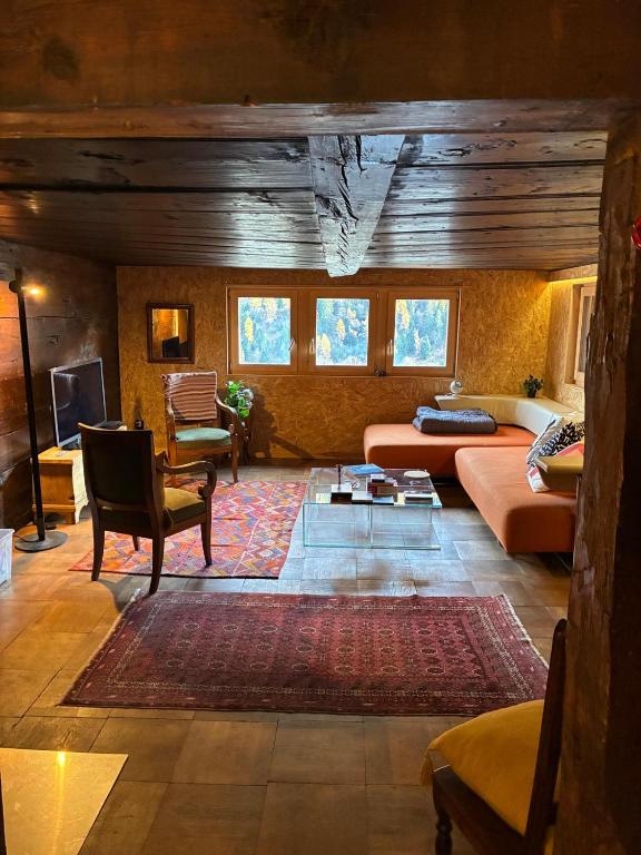 a living room with a couch and a table at Le refuge boisé in Hérémence
