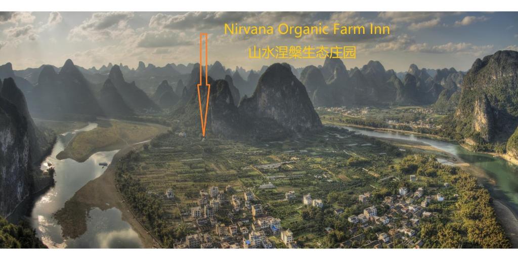 an aerial view of a city with a river and mountains at Nirvana Organic Farm Inn in Yangshuo