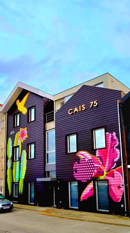 a purple building with a painting on the side of it at Cais 75 Studios & Suites in Aveiro