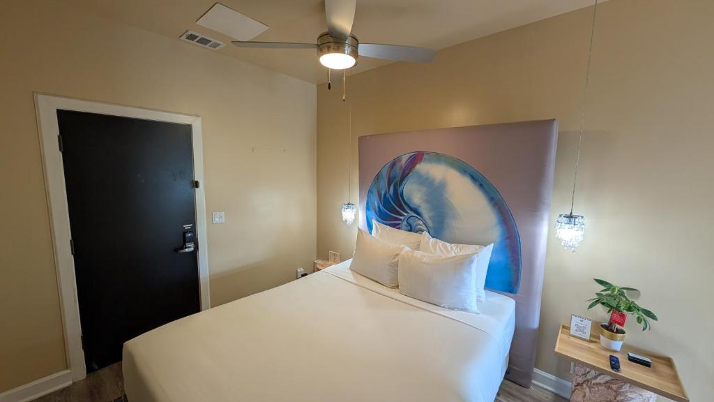 a bedroom with a bed with a painting on the wall at The Crescent Hotel Beverly Hills in Los Angeles