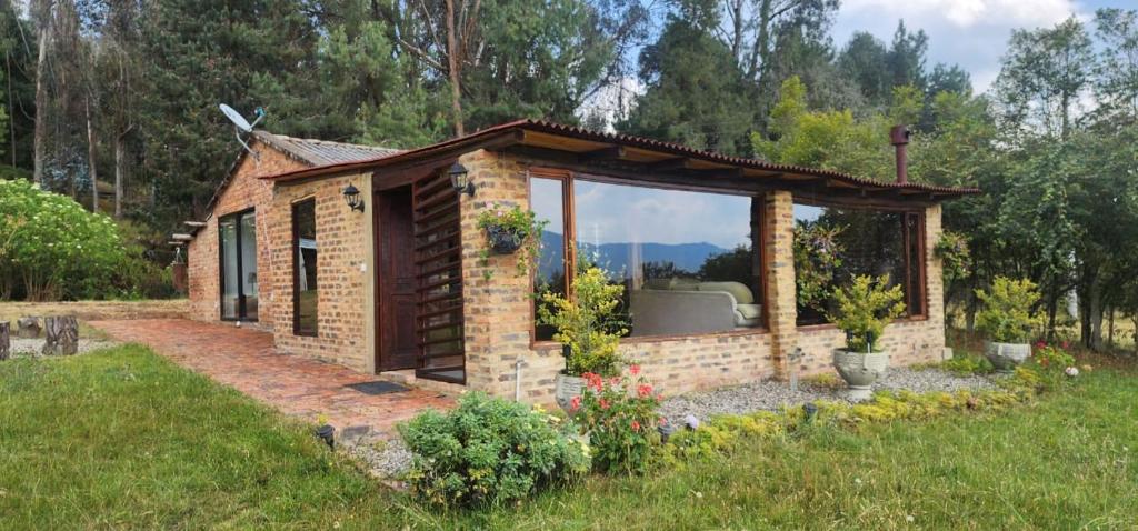 a small brick house with a pavilion in a yard at Finca El Recuerdo in Guatavita