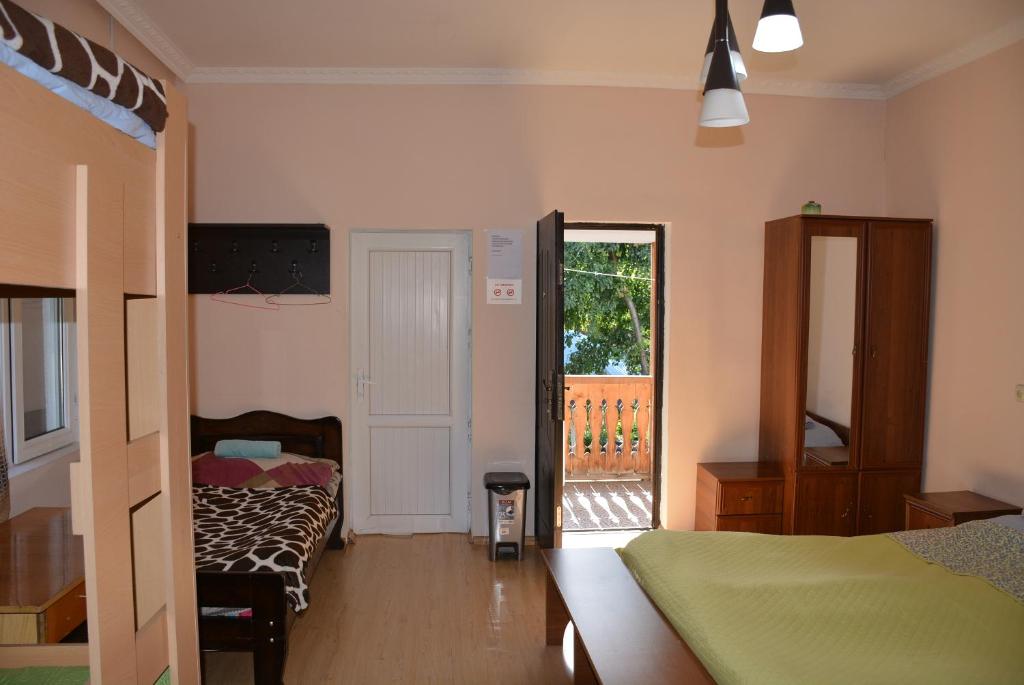 a bedroom with two beds and a door to a balcony at Budget Hostel in Mestia in Mestia