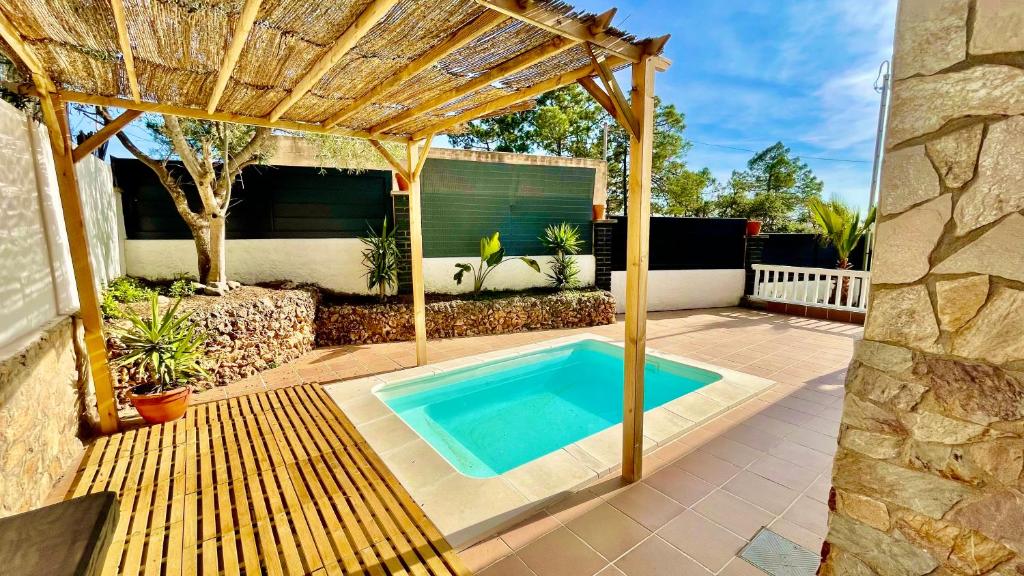 a swimming pool in a backyard with a wooden pergola at Villa Lloret De Mar in Lloret de Mar
