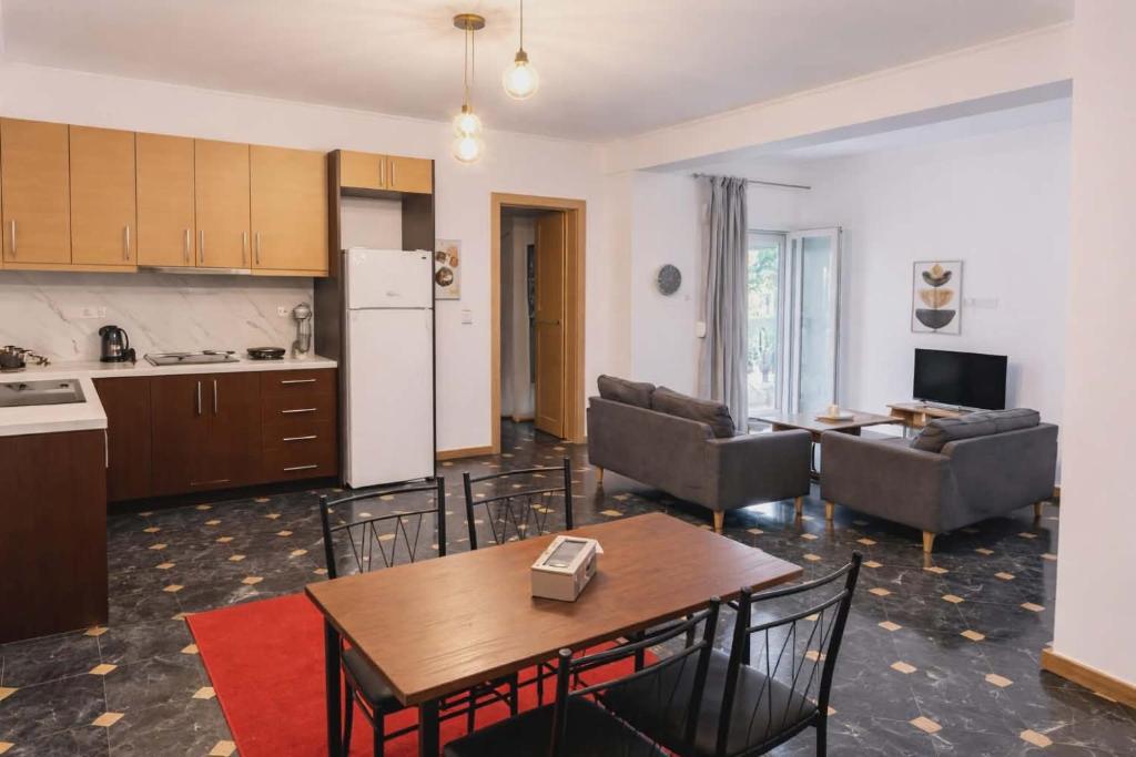 eine Küche und ein Wohnzimmer mit Tisch und Stühlen in der Unterkunft Pasithea's Apartment in Samos
