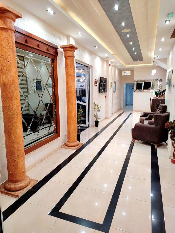 a lobby with columns and couches in a building at Hotel Aventus -Novi Pazar Banja in Novi Pazar