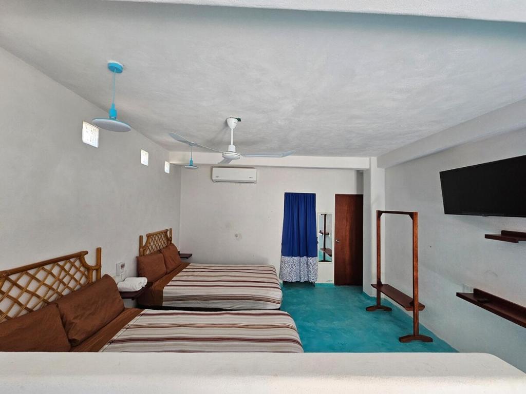 a room with two beds and a flat screen tv at Alojamiento Turquesa in Barrio Nuevo