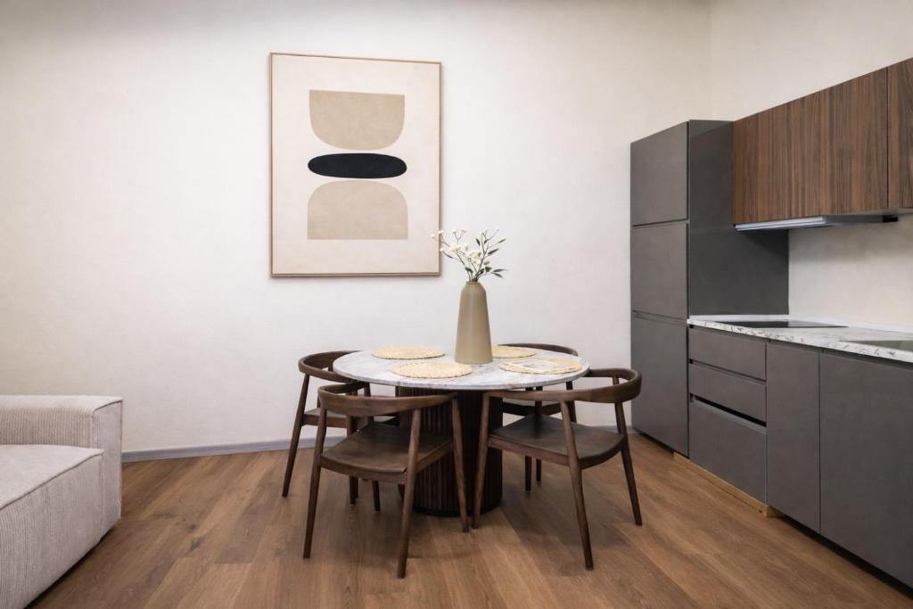 a kitchen with a table with chairs and a vase on it at Small Luxury In Centro Storico in Parma