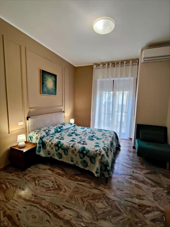 a bedroom with a bed and a couch and a window at Il Rovo Casa vacanze in Cava deʼ Tirreni