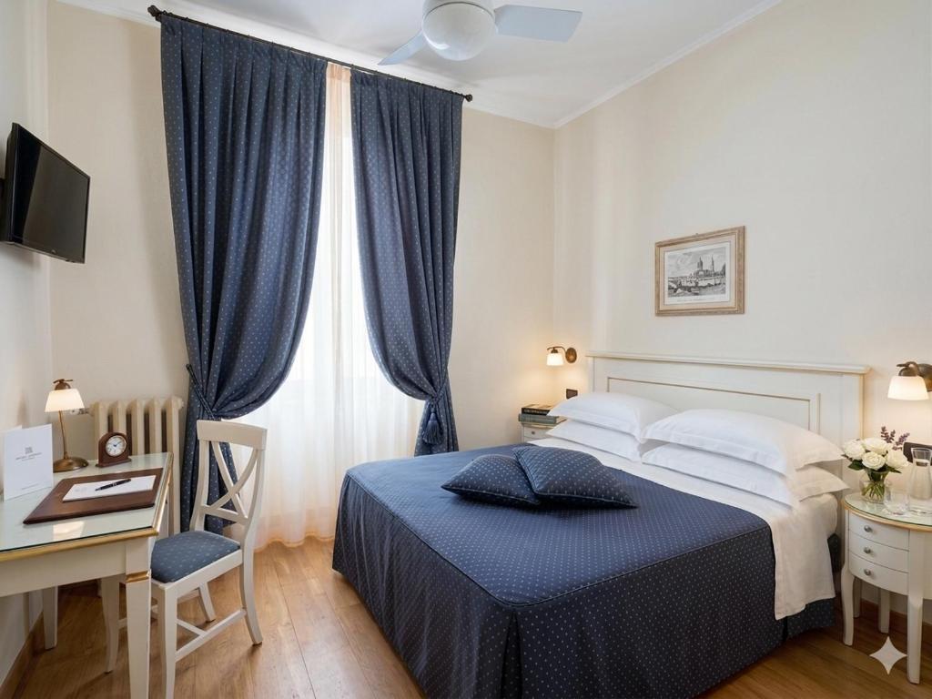 a bedroom with a bed and a desk with a computer at Hotel Primula in Alassio