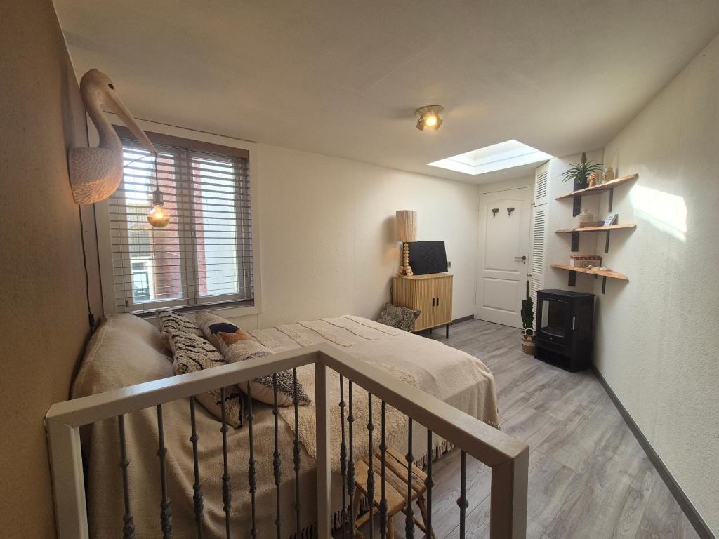 a small bedroom with a bed and a balcony at Zandvoort Beach Escape 2P in Zandvoort