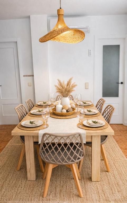 a dining room with a wooden table and chairs at Sa Tuna - Delta de l'Ebre in Riumar