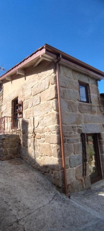 a stone building with a roof on the side of it at O Recuncho do Lito in Prado