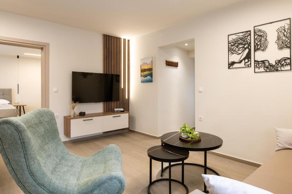 a living room with a couch and a tv at Nouvelles Roses 1 in Nea Roda