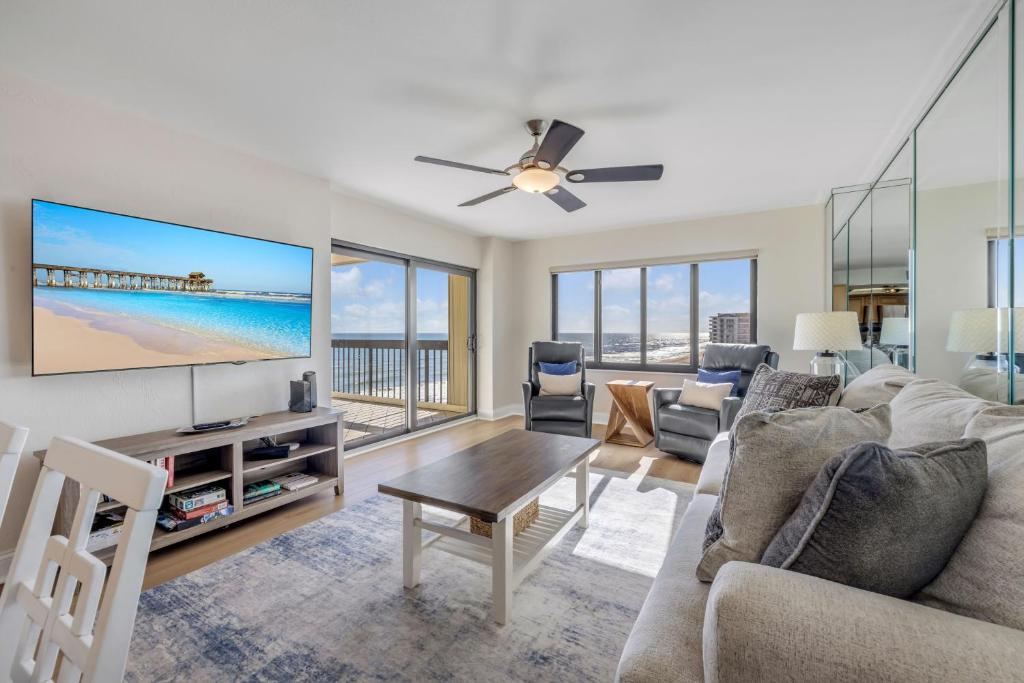 a living room with a couch and a tv at Sunrise beach views with top complex amenities and pool access! in Ormond Beach