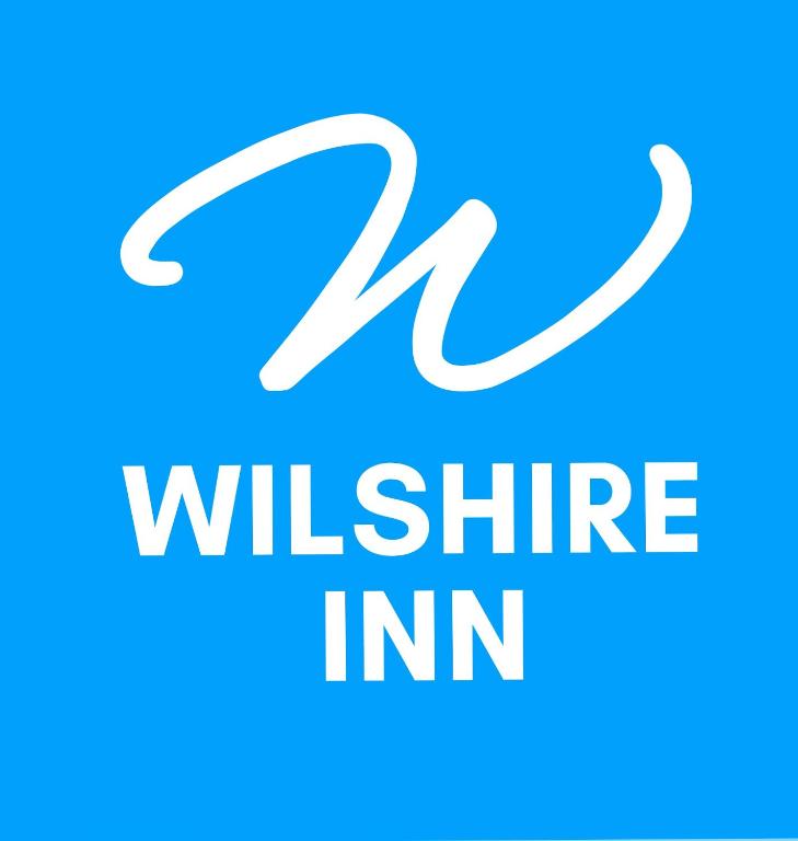 a logo for the wii elite inn at Wilshireinn Hotel in Claresholm