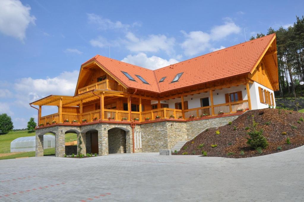 uma grande casa de madeira com um telhado vermelho em Szlovén Mintagazdaság em Felsőszölnök