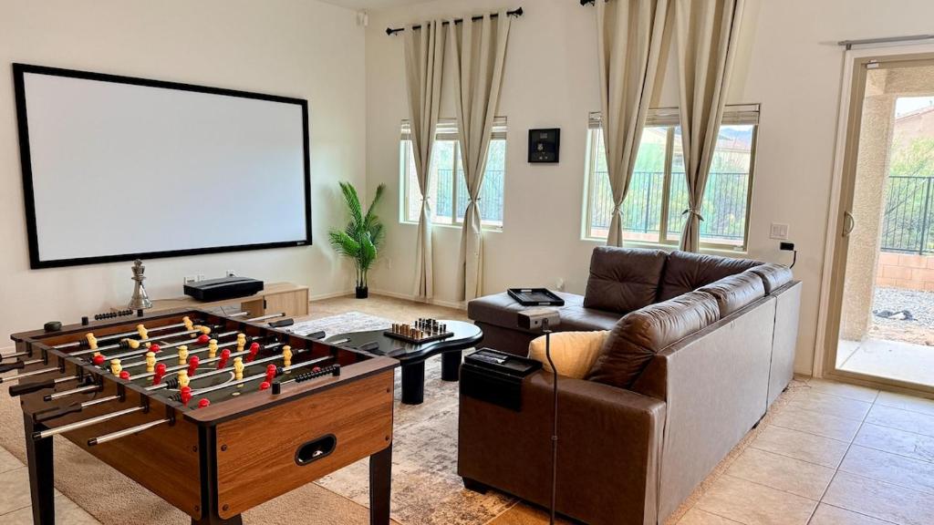 a living room with a couch and a table with a board at 4bed 2bath Retreat - 120inch Theater in Corona de Tucson
