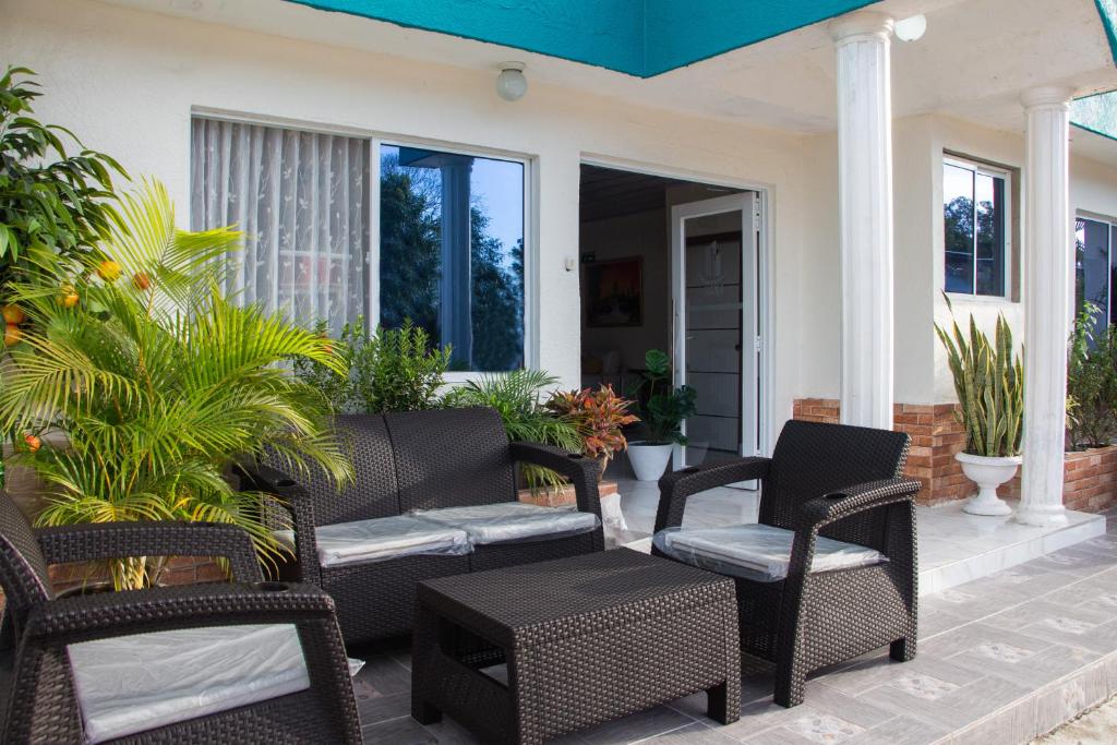 a porch with wicker chairs and a table at Hotel ALCALA in Mingueo
