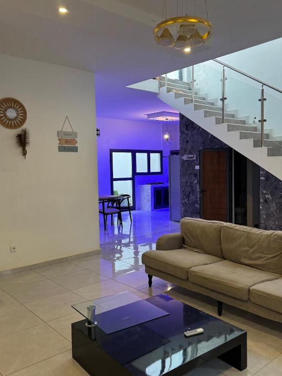 a living room with a couch and a staircase at chez Louise in Saly Portudal