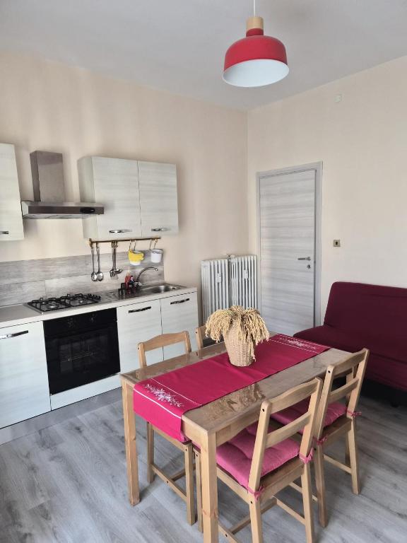 a living room with a table and a kitchen at Ca d'la Mondina Apartment in Vercelli