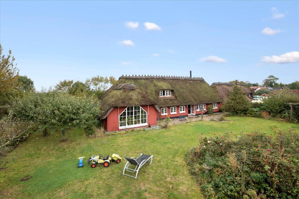 a red house with a grass roof on a field at Ferienhaus Sommer in Nordborg