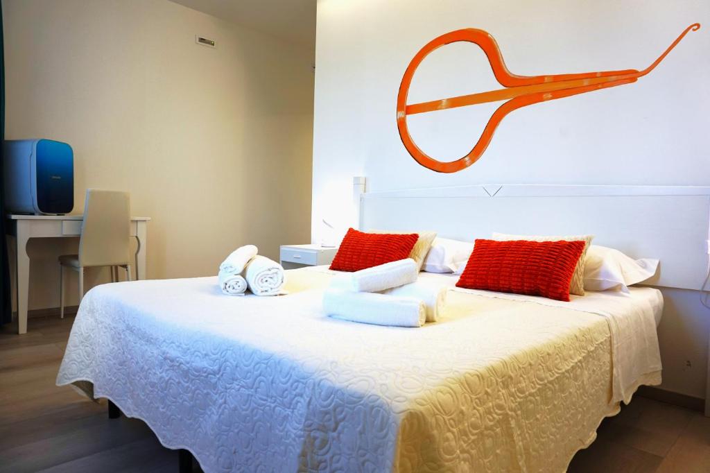 a large bed with red and white pillows on it at Sa Trunfa Rooms in Tortolì