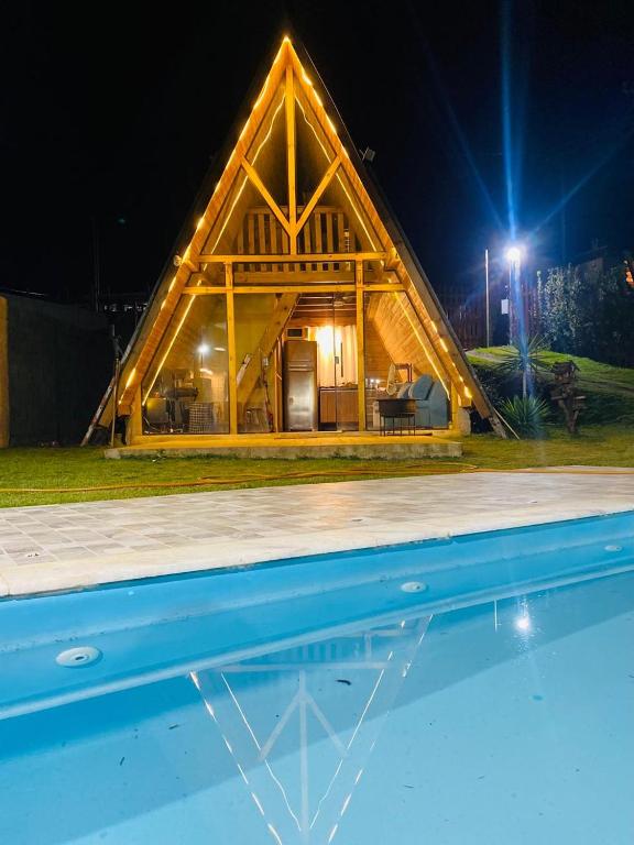 a large wooden house with a pool in front of it at Chalé Bruma in Pouso Alegre
