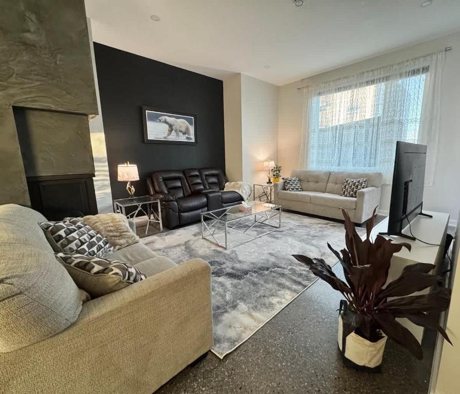 a living room with two couches and a fireplace at Modern House with Aurora Views in Yellowknife