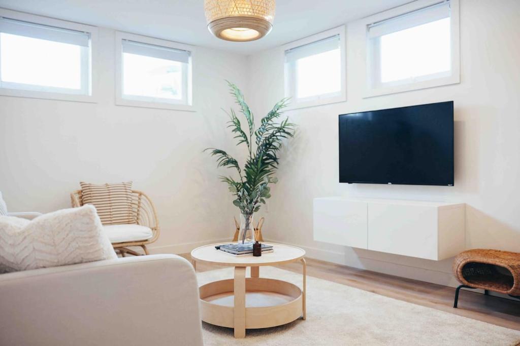 a living room with a tv and a couch and a table at California Suite in Fort Saint John