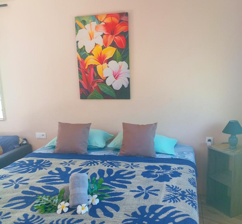 a bedroom with a bed with a painting on the wall at Hitimahana lodge in Fare