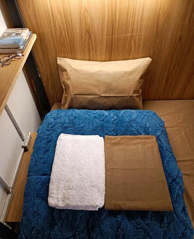 a small bedroom with a blue bed with a pillow at Eva hostel & chill Ayacucho in Ayacucho