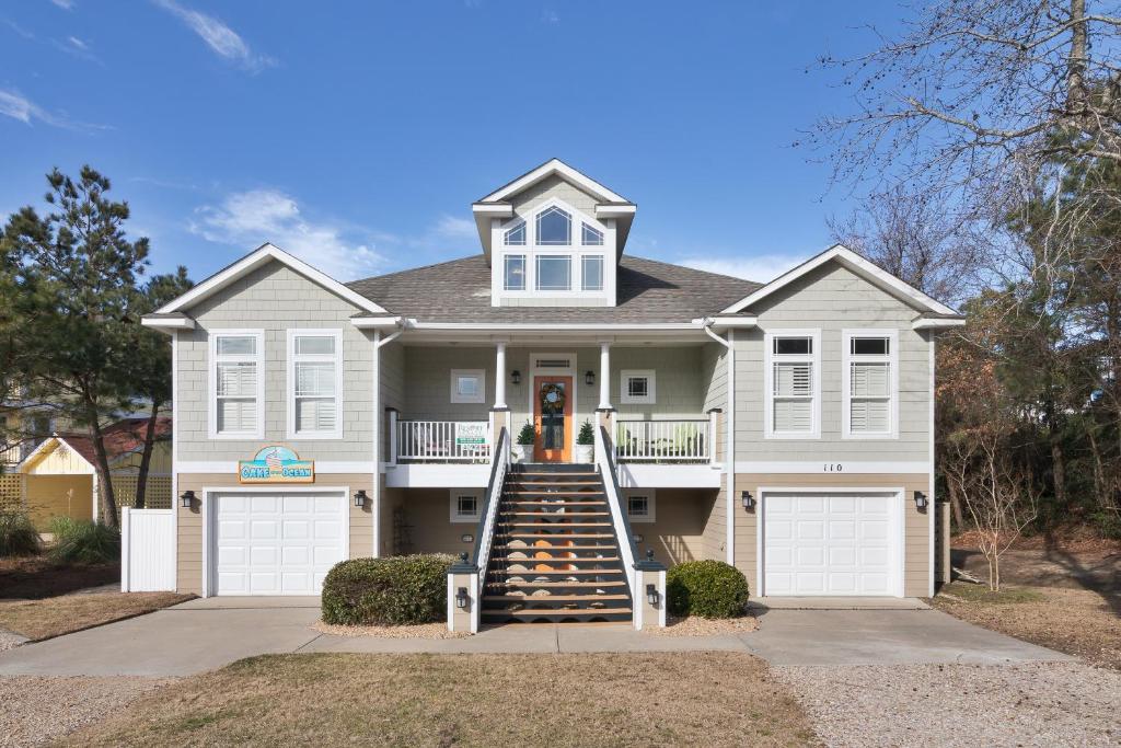 a house with a staircase leading to the front door at 4096 - Cake by the Ocean in Duck