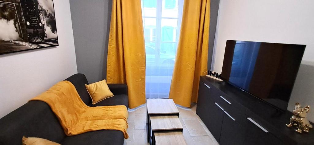 a living room with a couch and a television at Le Petit Jaune in Orthez