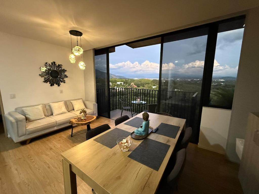 a living room with a table and a large window at Modern Apartment With Espectacular Panoramic Views in Pereira