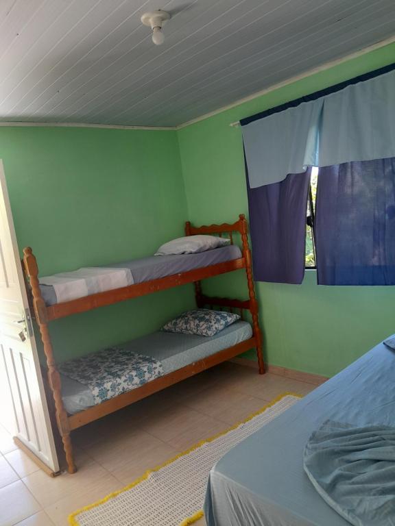 a bedroom with two bunk beds and a window at Pousada Elis Regina in Guaraqueçaba