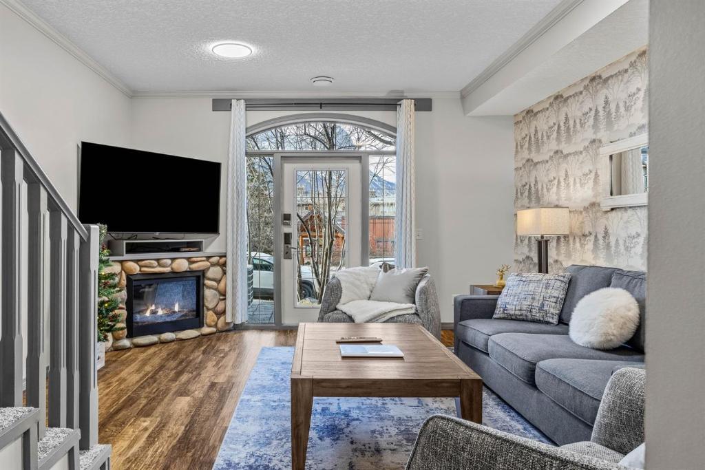 a living room with a couch and a fireplace at Mystic Springs #108 - Hot Tub and Pool, Pets managed by Little Sister Getaways in Canmore