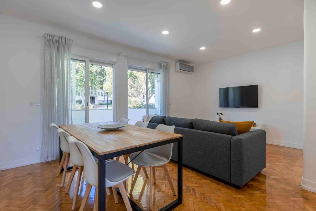 a living room with a table and a couch at Carcavelos Village III By Staycalm in Carcavelos