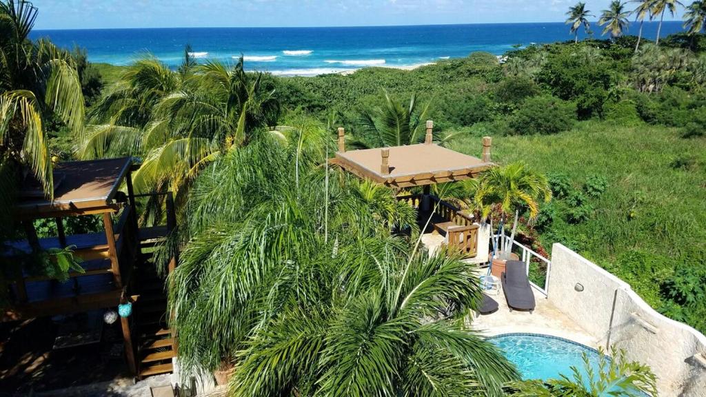 an aerial view of a resort with a swimming pool and the ocean at Jobos Beach House - Steps from the beach! in Isabela