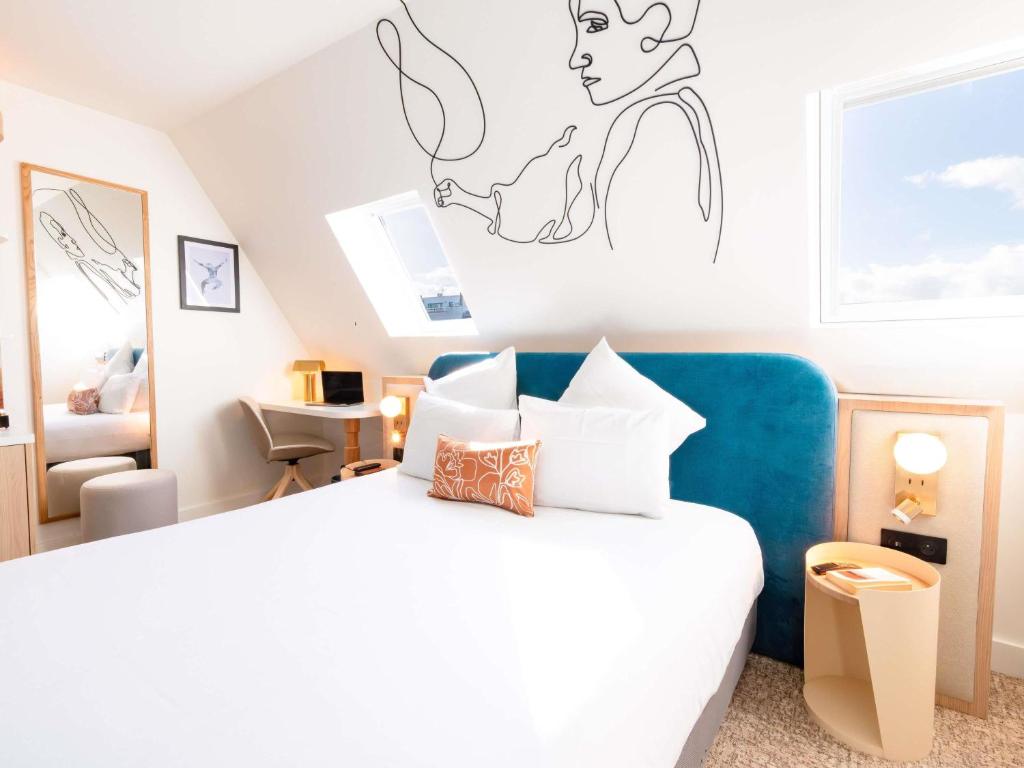 ein Schlafzimmer mit einem weißen Bett und einem Schreibtisch in der Unterkunft Mercure Paris Montparnasse Raspail in Paris