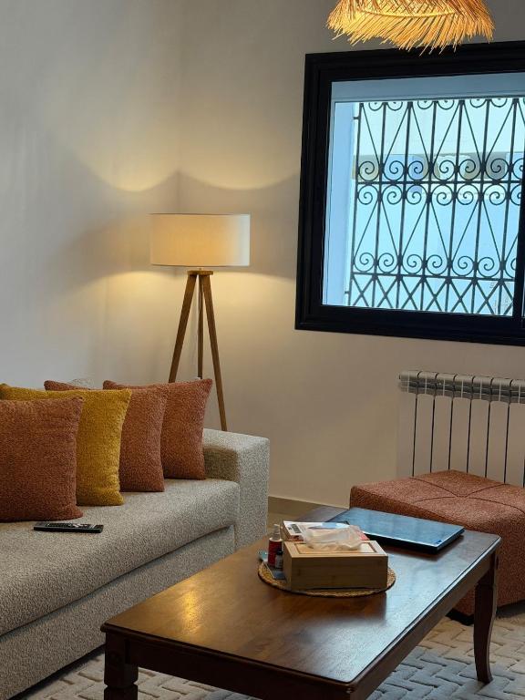 a living room with a couch and a table at Nestlya Apartment in Sukrah