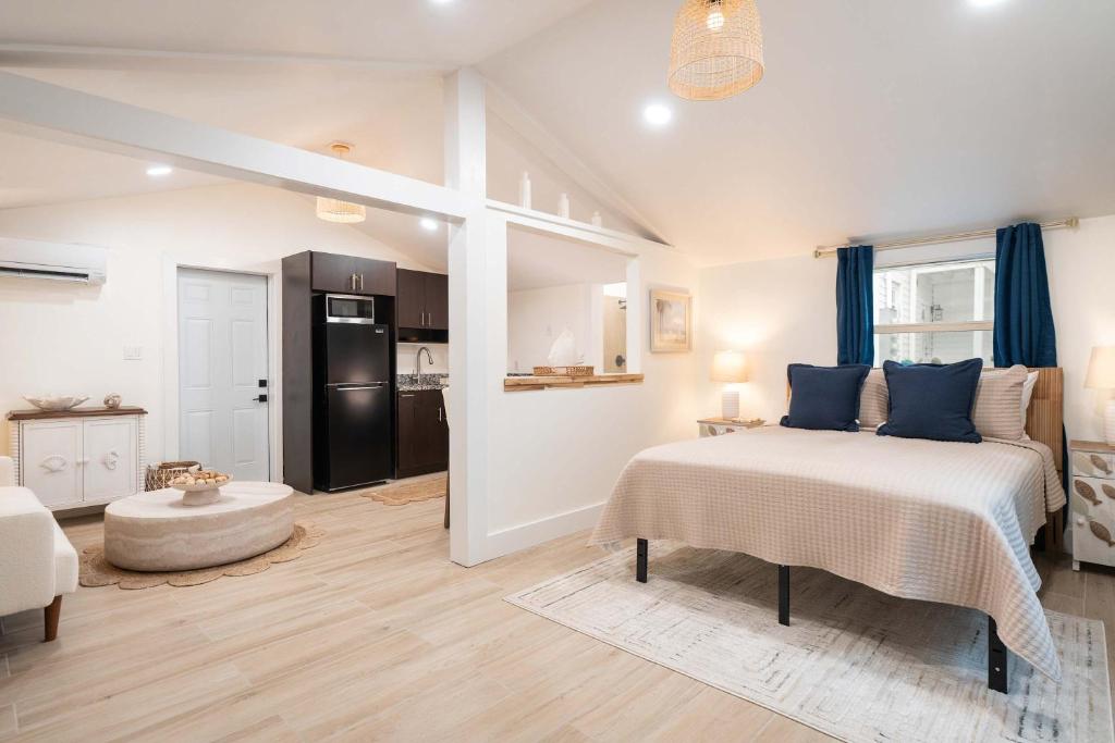 a bedroom with a large bed and a kitchen at The Margaret Suite in Key West