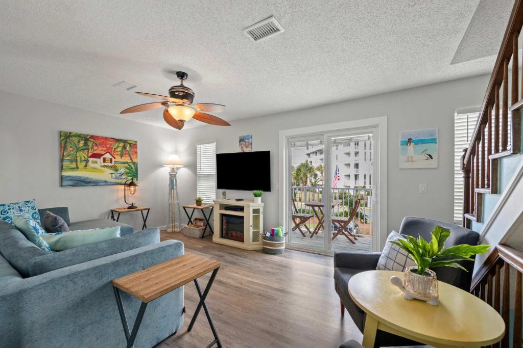 a living room with a blue couch and a tv at Bikini Bottom Destin Harbor Private Gated Beach in Destin