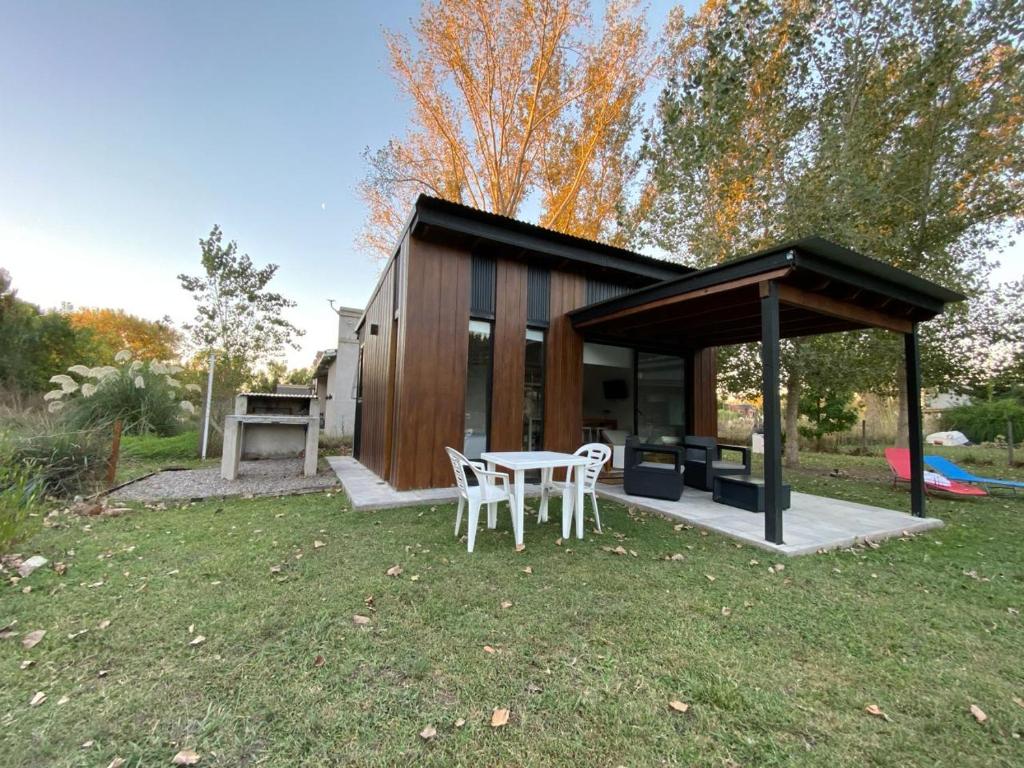 a small cabin with a table and chairs in the grass at Laguna y Tierra in Chascomús
